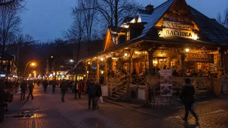 Góralska karczma z oświetloną werandą wieczorem